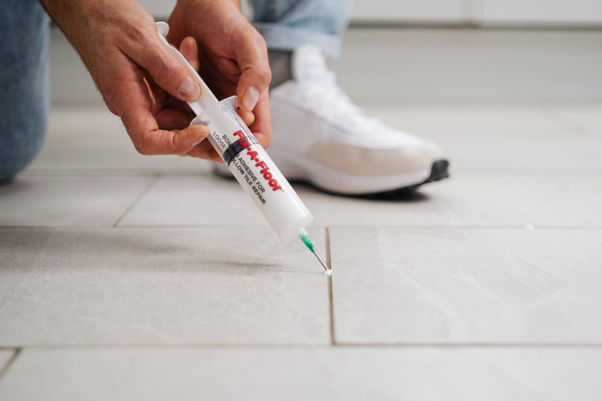 A man applying adhesives through 60ml Fix-A-Floor Syringe