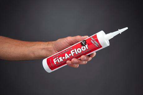Hand holding a Fix-A-Floor Extra Strength Bonding Floor Tile Adhesive tube used for repairing loose and hollow floor tiles.