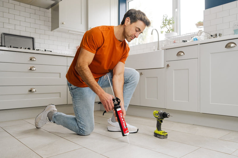 Load image into Gallery viewer, Man applying a Bonding Tube to the squeaky floor 
