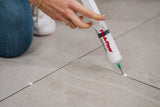A lady applying adhesives through 60ml Fix-A-Floor Syringe60ml Fix-A-Floor Syringe